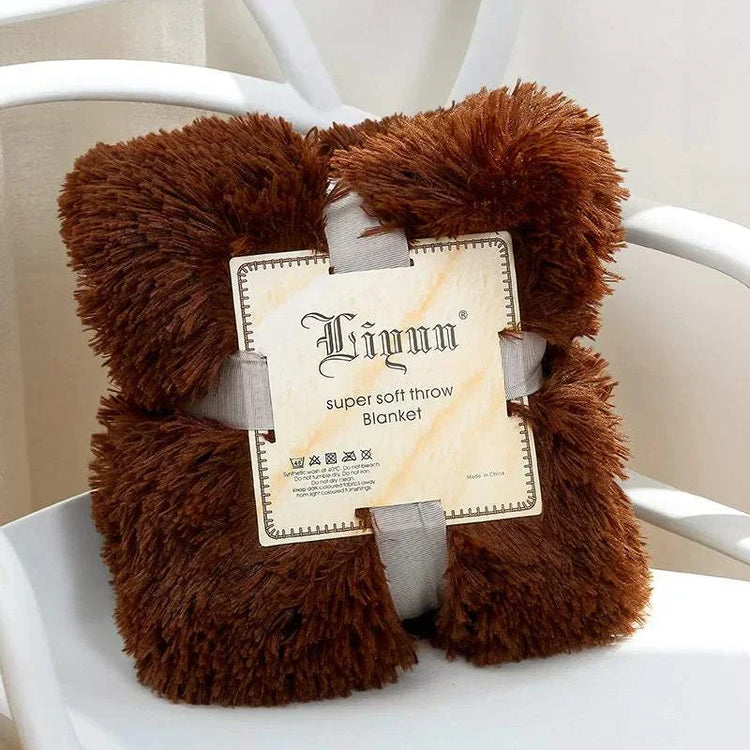 brown super soft coral fleece blanket folded with label on white chair