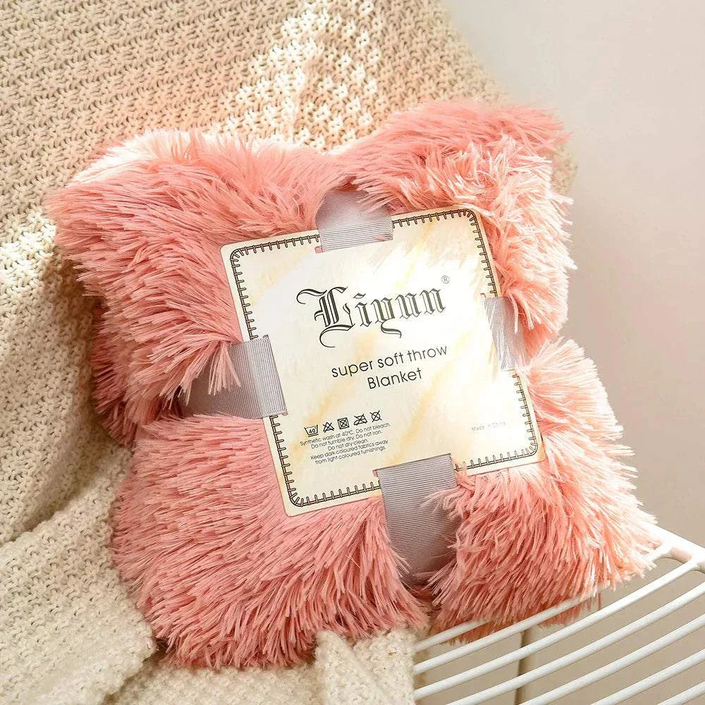 pink super soft coral fleece blanket with fluffy texture on beige knitted fabric background