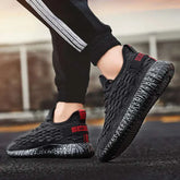 Black sports running shoes with textured design and comfortable sole held in hand