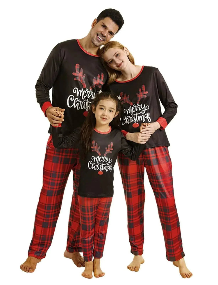 family in matching Christmas pajamas with red plaid pants and merry Christmas tops