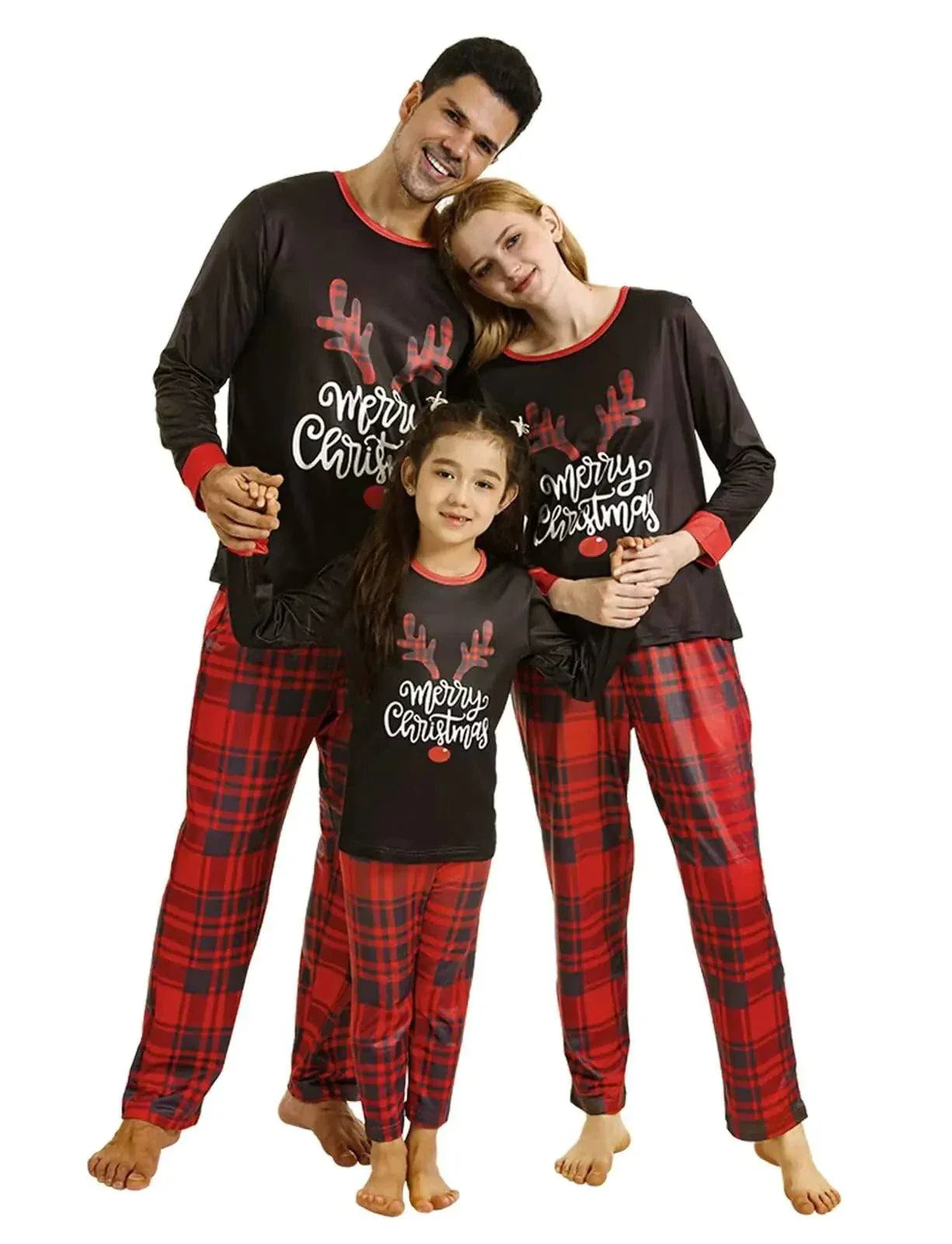 family wearing matching Christmas pajamas with reindeer antlers and merry Christmas text