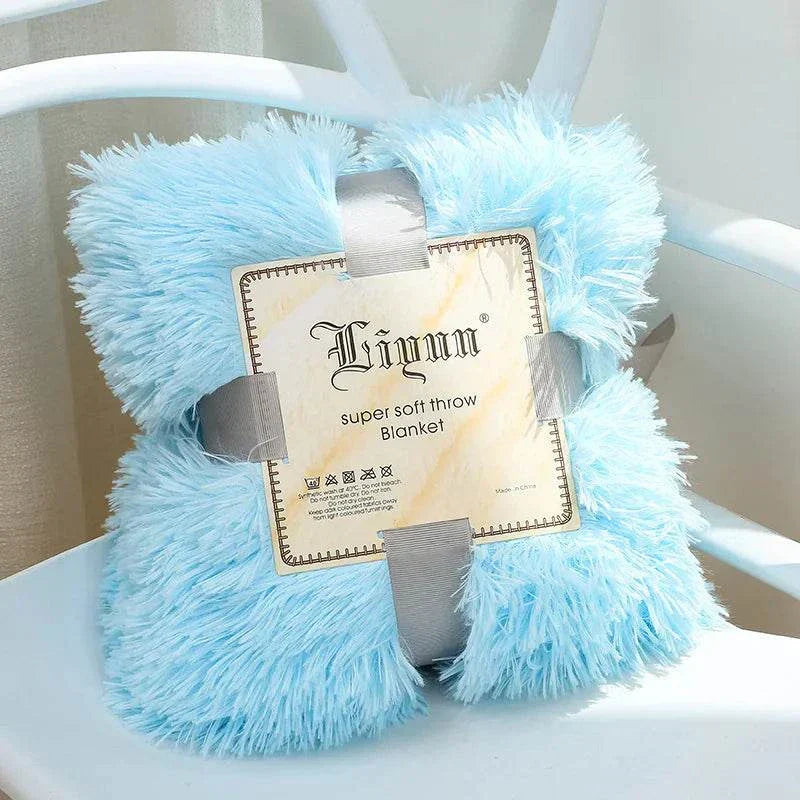 Light blue super soft coral fleece blanket folded on white chair with packaging label