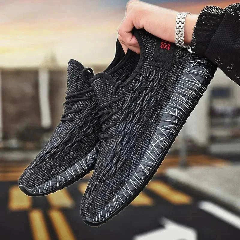 Black sports running shoes with textured design and comfortable sole held in hand