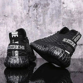 Black sports running shoes with textured design and comfortable sole held in hand