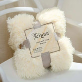 Creamy white super soft coral fleece blanket with fluffy texture and packaging label