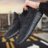 Black sports running shoes with textured design and comfortable sole held in hand