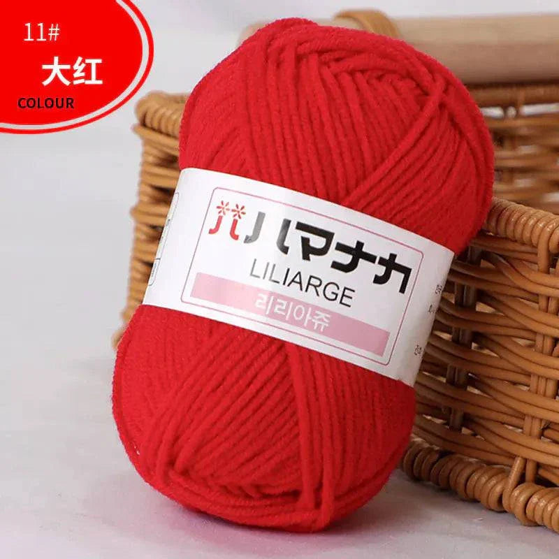 Red 4-ply milk cotton yarn ball for baby dolls and crochet near woven basket